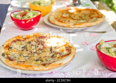 Pizzateile auf einem Teller auf einem Tisch mit Tischdecke und Besteck, Deutschland Stockfoto