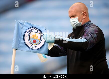 Etihad Stadium Head Groundsman Lee Jackson sprüht während der Getränkepause während des Premier League-Spiels im Etihad Stadium in Manchester die Eckflagge mit Desinfektionsmittel. Stockfoto