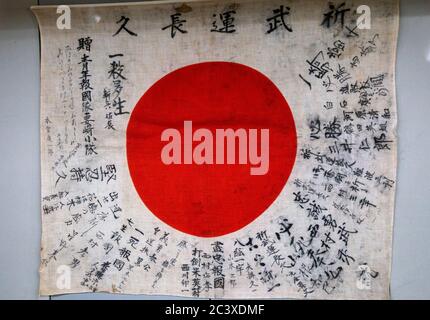 Eine japanische Flagge, die einem Kamikaze-Soldaten gehörte, der sie auf dem Kopf getragen hätte, die in Bletchley Park, Bletchley, Buckinghamshire, Großbritannien ausgestellt wurde. Stockfoto