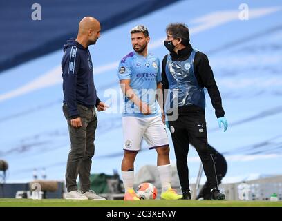 Sergio Aguero von Manchester City spricht mit Manager Pep Guardiola, der während des Spiels der Premier League im Etihad Stadium in Manchester verletzt vom Spielfeld kommt. Stockfoto