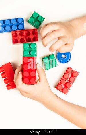 Kinderhände sammeln den Designer aus Würfeln Stockfoto