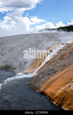 Heißes Wasser aus dem Midway-Becken fließt in den firehole River im Yellowstone National Park. Stockfoto