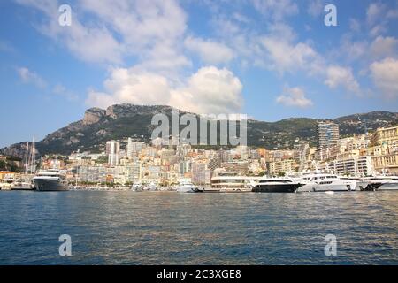 Blick vom Mittelmeer auf das Fürstentum Monaco und Monte Carlo mit seinen dichten Skyscrappern, dem Yachthafen, den Yachten, dem Palast und dem Casino. Stockfoto