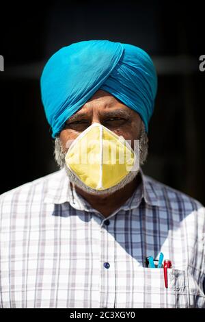 Westminster, London, England. Juni 2020. Ein älterer asiatischer Sikh-Mann, der während der Coronavirus-Lockdown in London, England, einen leuchtend türkisfarbenen Turban und eine gelbe Schutzmaske trägt. (Foto von Sam Mellish / Alamy Live News) Stockfoto