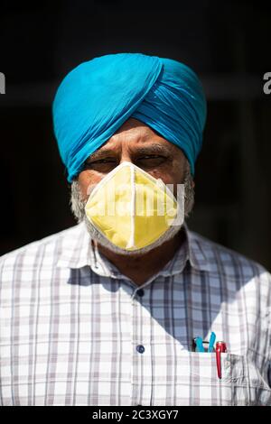 Westminster, London, England. Juni 2020. Ein älterer asiatischer Sikh-Mann, der während der Coronavirus-Lockdown in London, England, einen leuchtend türkisfarbenen Turban und eine gelbe Schutzmaske trägt. (Foto von Sam Mellish / Alamy Live News) Stockfoto