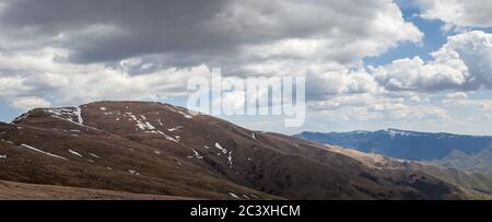Panoramablick auf den Gipfel von Midzor und das alte Berghochland Das Ende des Winters mit kommen verbleibenden Schnee und bewölkt Himmel Stockfoto