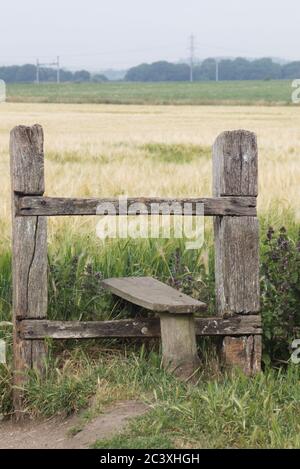 old wooden countryside Stile leading into a crop filed Stockfoto