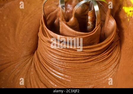 Mischen von Kakaopulver, Mehl und geschlagenen Eiern. Schokoladenkuchen. Serie. Stockfoto