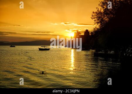 Sonnenuntergang über Ohrid See mit Silhouette des Heiligen Johannes der Theologe, Kaneo Kirche gegen dramatischen Himmel. Nord-Mazedonien, Europa. Stockfoto