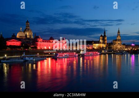 Dresden, Deutschland. Juni 2020. Das Lipsiusgebäude (l), die Akademie der Künste und die Salonschiffe der Schächsischen Dampfschiffahrt sind abends rot beleuchtet, dahinter die Frauenkirche (l-r), das Ständehaus, der Hausmannsturm und die Hofkirche. Sachsen beteiligt sich an der bundesweiten Kampagne "Nacht des Lichts". In der Nacht zum 23. Juni werden Veranstaltungsorte und ausgewählte Gebäude in ganz Deutschland rot beleuchtet, um auf die dramatische Situation der Corona-Pandemie in der Eventbranche aufmerksam zu machen. Quelle: Robert Michael/dpa-Zentralbild/dpa/Alamy Live News Stockfoto