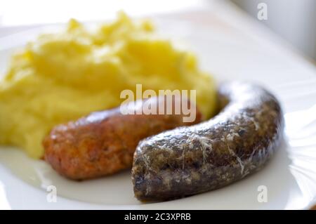 Feine ungarische Würste mit Kartoffeln auf weißem Teller Stockfoto