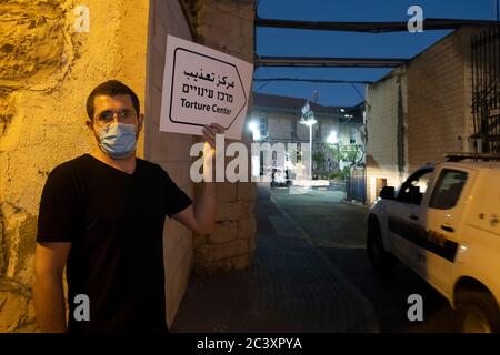 Ein Protestler, der wegen der COVID-19-Coronavirus-Pandemie Gesichtsmaske trägt, hält ein Banner mit der Aufschrift "Folterzentrum", während arabisch-israelische Studenten und Aktivisten von Hadasch, einer linksextremen politischen Koalition, die von der israelischen Kommunistischen Partei und anderen linken Gruppen gebildet wurde, an einem Protest vor dem russischen Kompound teilnehmen („Al-Maskoubiyya“, auf Arabisch) Haftanstalt in West-Jerusalem gegen die Verhaftung palästinensischer Studenten aus Gründen wie Teilnahme an Demonstrationen und das Werfen von Steinen an israelische Soldaten. Quelle: Eddie Gerald/Alamy Live News Stockfoto