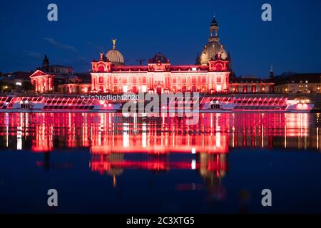 Dresden, Deutschland. Juni 2020. Die Kunstakademie und die Br·ühlsche Terrasse sind abends rot beleuchtet und spiegeln sich im Wasser der Elbe wider. Sachsen beteiligt sich an der bundesweiten Kampagne "Nacht des Lichts". In der Nacht zum 23. Juni werden Veranstaltungsorte und ausgewählte Gebäude in ganz Deutschland rot beleuchtet, um auf die dramatische Situation der Corona-Pandemie in der Eventbranche aufmerksam zu machen. Quelle: Sebastian Kahnert/dpa-Zentralbild/dpa/Alamy Live News Stockfoto