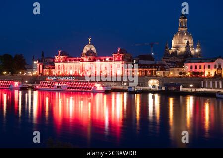 Dresden, Deutschland. Juni 2020. Die Kunstakademie und die Brühlsche Terrasse sind abends rot beleuchtet und spiegeln sich im Wasser der Elbe wider. Sachsen beteiligt sich an der bundesweiten Kampagne "Nacht des Lichts". In der Nacht zum 23. Juni werden Veranstaltungsorte und ausgewählte Gebäude in ganz Deutschland rot beleuchtet, um auf die dramatische Situation aufgrund der Corona-Pandemie in der Eventbranche aufmerksam zu machen. Quelle: Sebastian Kahnert/dpa-Zentralbild/dpa/Alamy Live News Stockfoto