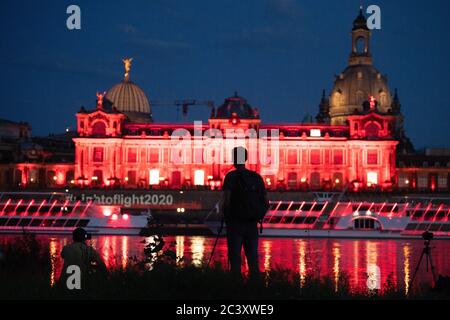 Dresden, Deutschland. Juni 2020. Die Kunstakademie und die Brühlsche Terrasse sind abends rot beleuchtet und spiegeln sich im Wasser der Elbe wider. Sachsen beteiligt sich an der bundesweiten Kampagne "Nacht des Lichts". In der Nacht zum 23. Juni werden Veranstaltungsorte und ausgewählte Gebäude in ganz Deutschland rot beleuchtet, um auf die dramatische Situation aufgrund der Corona-Pandemie in der Eventbranche aufmerksam zu machen. Quelle: Sebastian Kahnert/dpa-Zentralbild/dpa/Alamy Live News Stockfoto