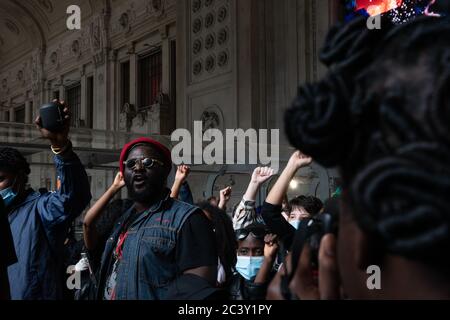 Junge Demonstranten heben ihre rechten Fäuste während der Protestversammlung in Solidarität mit Black Lives Matter Bewegung am Mailänder Hauptbahnhof. Stockfoto