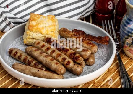 Gegrilltes Schweinefleisch Frühstück Würstchen und ein Keks in einem Teller auf einer Bambusmatte Stockfoto