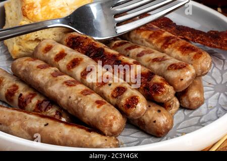 Gegrilltes Schweinefleisch Frühstück Würstchen und ein Keks in einem Teller auf einer Bambusmatte Stockfoto