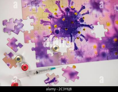 Studio Schuss Puzzle mit Coronavirus-Modell und Impfstofffläschchen Und Spritze Stockfoto