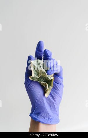Studio Schuss der Hand in Latex-Handschuh hält zerknittert Dollar Bill Stockfoto
