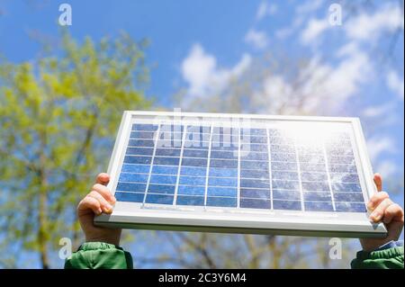 Nahaufnahme von Jungen (4-5) Hände halten Solarpanel gegen den Himmel Stockfoto