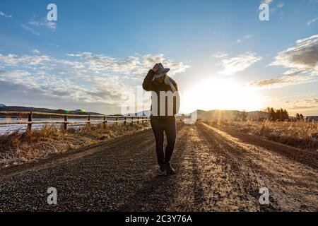 USA, Idaho, Sun Valley, Frau bei Sonnenaufgang auf Landstraße Stockfoto