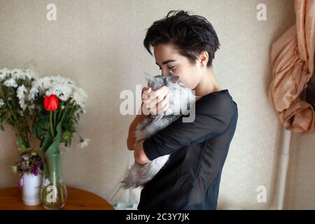 Frau kuschelt Katze zu Hause Stockfoto