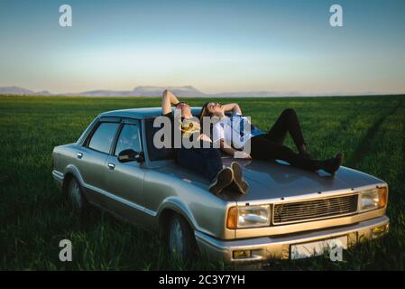 Ukraine, Krim, Paar auf altmodischen Auto in ländlicher Landschaft sitzen Stockfoto