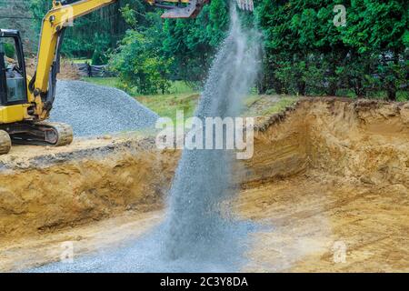 Bagger graben Schaufel schaufeln Kies von im Gebäude Stiftung Stockfoto