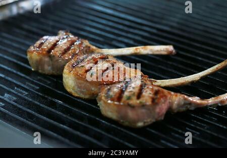 Drei Rinderknochen in Rib Eye Steak mit Grillflecken auf dem Grill. Stockfoto