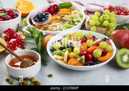 Schale mit gesunden frischen Obstsalat auf grauem Hintergrund. Stockfoto