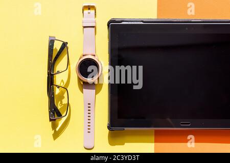 Flaches Lay feminine Arbeitsplatz mit Tablet, Notebook, Brille, Handgelenk watch.Stylish weibliche Bürotisch, Draufsicht.Work zu Hause.Smart Büro, Abstand Stockfoto
