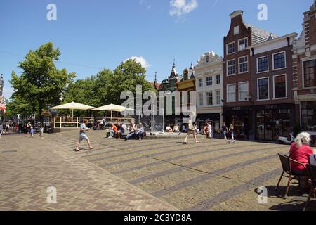 Alte Steinbrücke über Mient Kanal, mit Terrassen und viele Besucher und Touristen. Juni, Zentrum von Alkmaar, Niederlande. Stockfoto