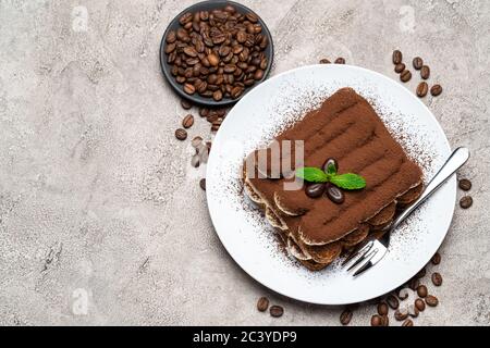 Klassisches Tiramisu Dessert auf Keramikplatte auf Betongrund Stockfoto
