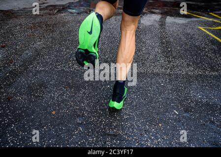 ROM, ITALIEN, JUNI 23. 2020: Nike Laufschuhe ALPHAFLY NEXT%. Umstrittener grüner Leichtathletik-Schuh auf den Beinen des Profisportlers, der auf der Straße läuft. Stockfoto