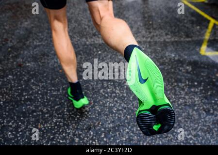 ROM, ITALIEN, JUNI 23. 2020: Nike Laufschuhe ALPHAFLY NEXT%. Umstrittener grüner Leichtathletik-Schuh auf den Beinen des Profisportlers, der auf der Straße läuft. Stockfoto