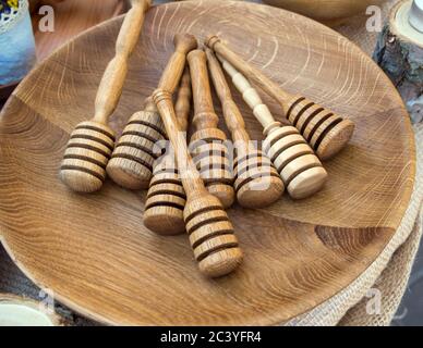 Löffelstangen für Honig liegen auf einer Holzschale Stockfoto