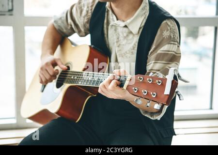 Der Gitarrist spielt Gitarre. Oder eine Person lernt, Gitarre zu spielen. Stockfoto