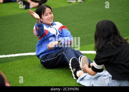 (200623) -- PEKING, 23. Juni 2020 (Xinhua) -- Cai Qiyan besucht eine P.E. Klasse an der Sanhe Experimental School im Bezirk Jinzhai, Ostchina Anhui Provinz, 19. Juni 2020. Cai Qiyan genießt den Blick auf die fließenden Wolken von einer der Teeplantagen auf den Bergen. Aber der Spaß war auch ein Luxus für den 15-Jährigen, der mit angeborener Skoliose diagnostiziert wurde. Von Anfang an hatte Qiyan es extrem schwierig gefunden, ihre Wirbelsäule aufrecht zu halten. In der Tiefe der Dabie Berge, Qiyan hatte zwei Stunden auf dem Weg zur Schule und nach Hause zu verbringen, da es "dauerte viel länger mit einem Fuß Stockfoto