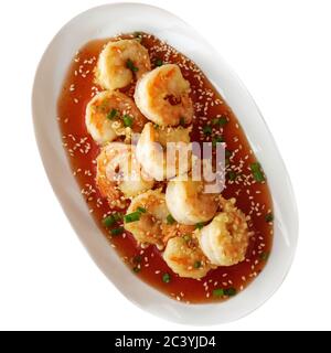 Tempura-Garnelen mit süßer und saurer Sauce, Sesam und gehackter grüner Zwiebel. Draufsicht Stockfoto