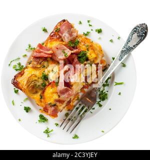 Käsiger Auflauf mit Süßkartoffeln, Speck, Eiern und Kirschtomaten. Isoliert auf weißem Hintergrund. Stockfoto