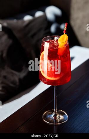 Glas aperol Spritz Cocktail mit Grapefruit und Erdbeeren auf Holztisch im Café Stockfoto