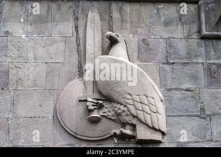 Bas-Relief Emblem von Adler, Schwert und Schild, neben Statue von Mesrop Mashtots und seinem Schüler Koryun, Matenadaran Bibliothek, aka, Mesrop Mashtots Stockfoto