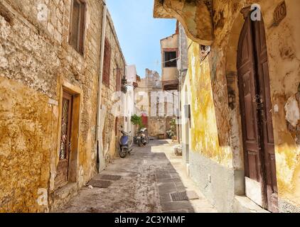 Rhodos Stadt, Rhodos, Griechenland - 1. Juli 2019: Mittelalterliche Stadtmauern der alten Rhodos Stadt mit Türen von Häusern und Mopeds auf dem Hof Stockfoto