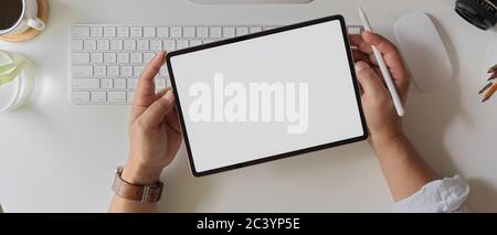 Overhead-Aufnahme des Geschäftsmannes mit leerem Bildschirm Tablet über Computer-Tastatur und Zubehör auf weißem Schreibtisch Stockfoto