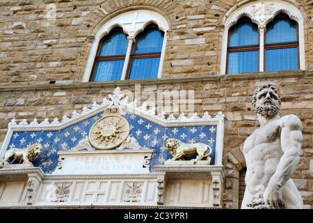 Detail des Palazzo Vecchio, gelegen auf der Piazza della Signoria in Florenz, mit einem dekorativen Marmor-Frontispiz aus dem Jahr 1528 und einer Statue des Herkules und Stockfoto