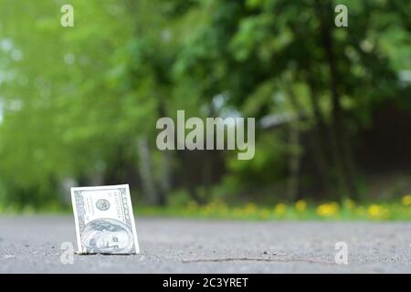 Auf dem Bürgersteig liegt ein 100-Dollar-Schein Stockfoto