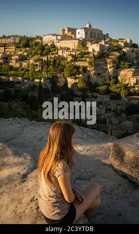 Junge weibliche Touristen mit Blick auf das mittelalterliche französische Dorf Gorde am Abend, Provence, Süden von frankreich. Stockfoto