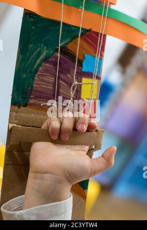 Kinder tragen einen Roboterarm aus Pappe. Karton Hand in Gebrauch. Kinder Dekoration eines Papparms während DER DAMPFWERKSTATT gemacht. Tinke Stockfoto