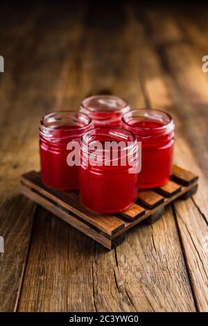 Rot gefärbte alkoholische Schützen oder erschossen Getränke auf Holztisch Stockfoto